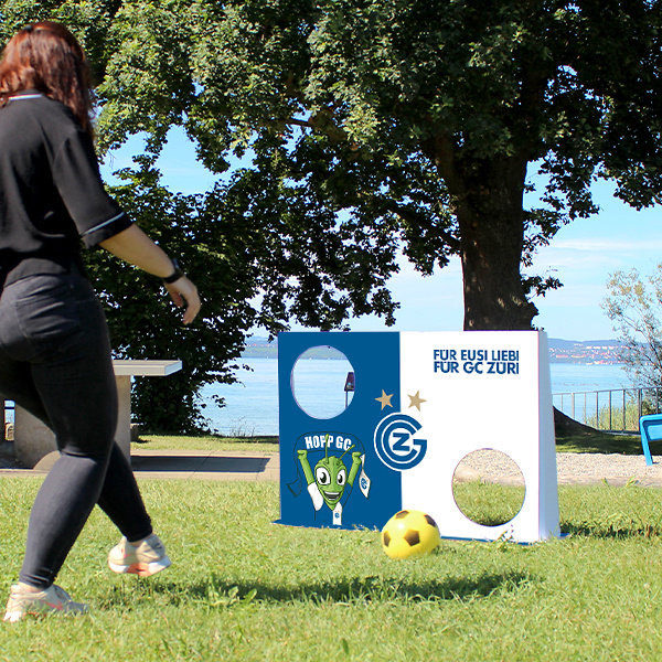 Woman playing outdoors with the GC goal wall and soft ball